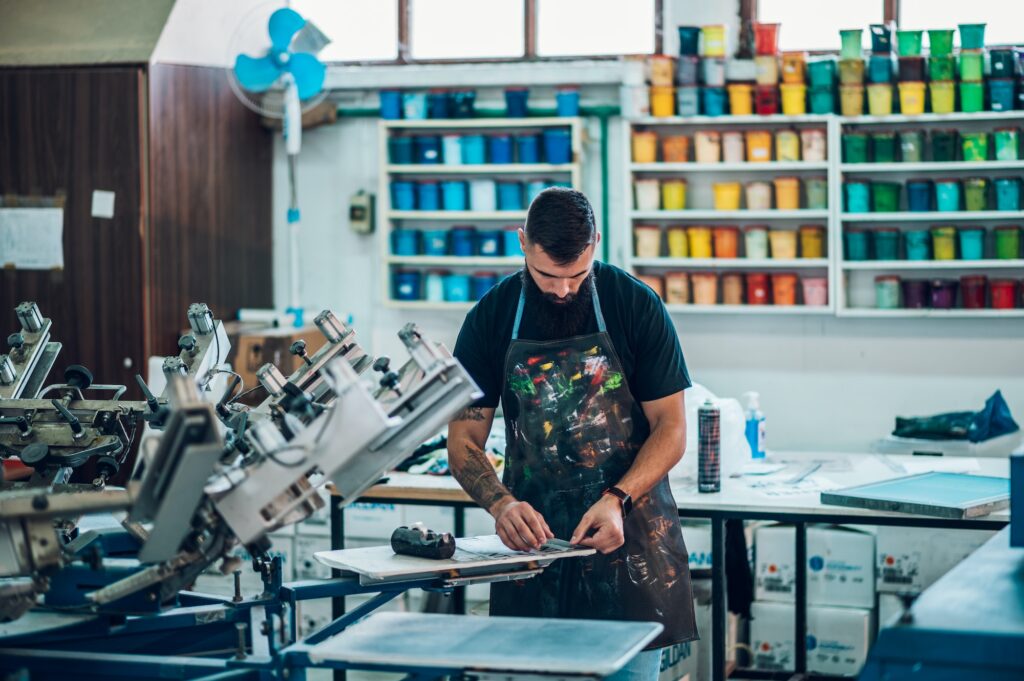 Male worker preparing screen printing film in a workshop